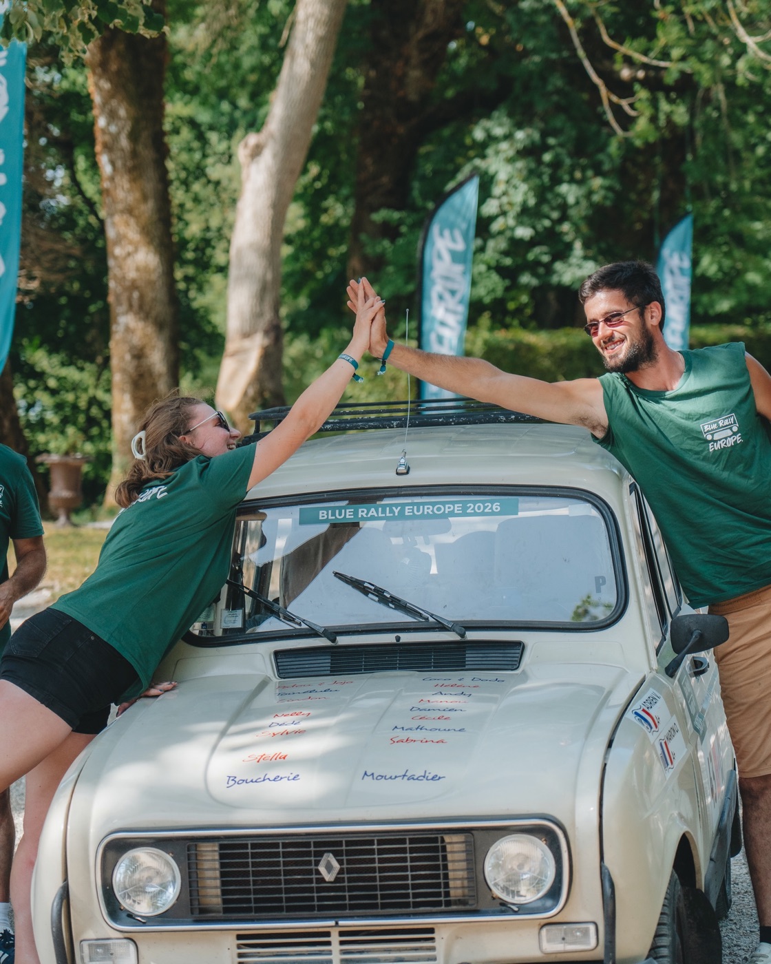 Deux participants se congratulent au-dessus d&rsquo;une Renault 4 à l&rsquo;arrivée